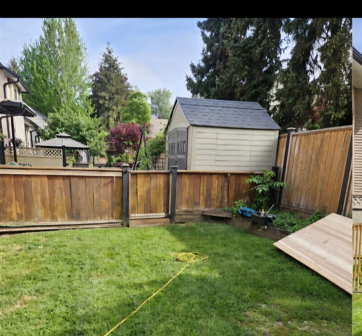 The same backyard before, with its weathered aging fence