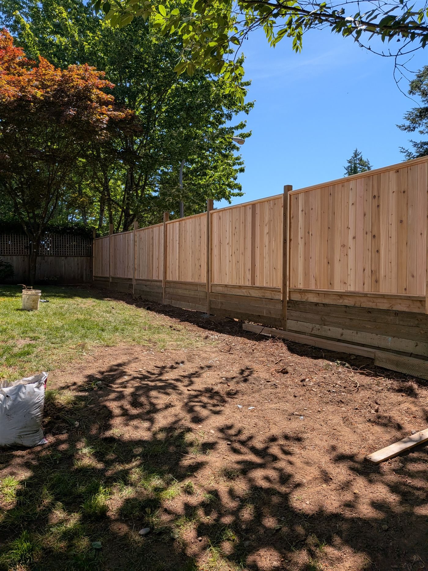 Newly installed board-on-board western red cedar fence with capped posts