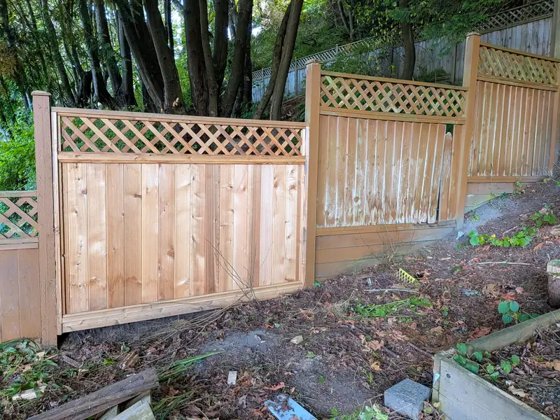 The same spot with a new lattice-top cedar panel set plumb between the posts, following the slope